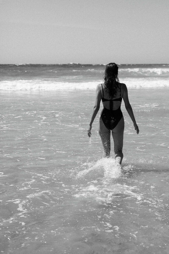 Woman walking into the water on a beach